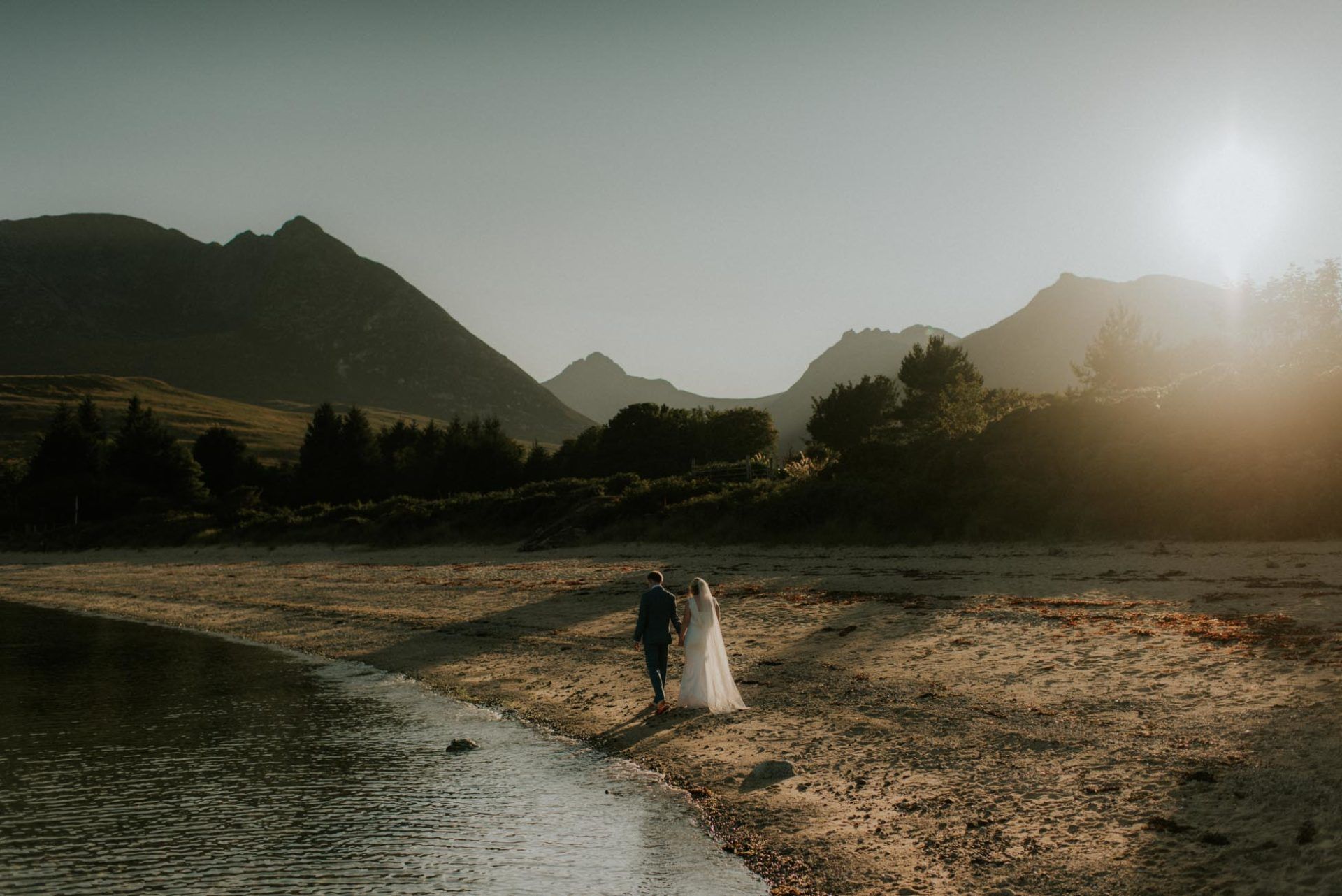 bride and groom walking along beach